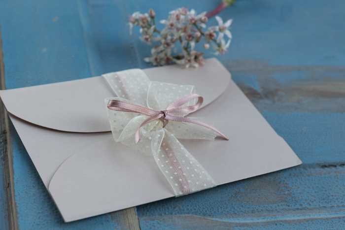 wedding invitation in envelope, tied with ribbon 